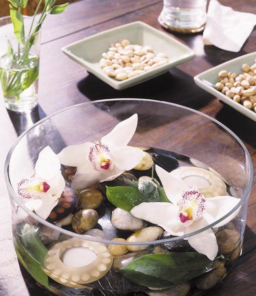 10 - Flowers and pebbles inside a glass bow placed as a table centerpiece