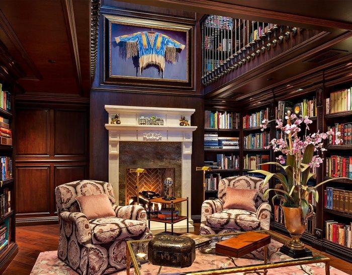 Luxurious traditional home library - with wood shelves and club armchairs