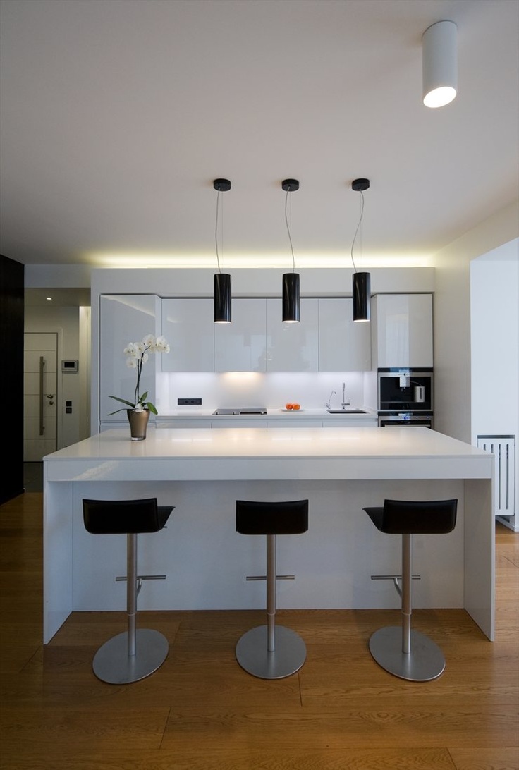 Contemporary white kitchen - with black bar stools and white island