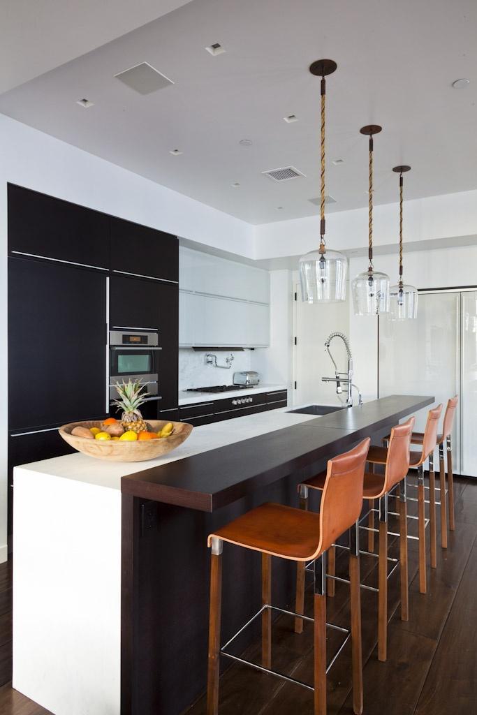 Modern black and white kitchen - with brown bar stools