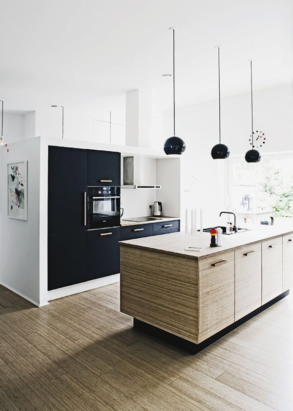 Modern white kitchen - with black pendats and wood countertops