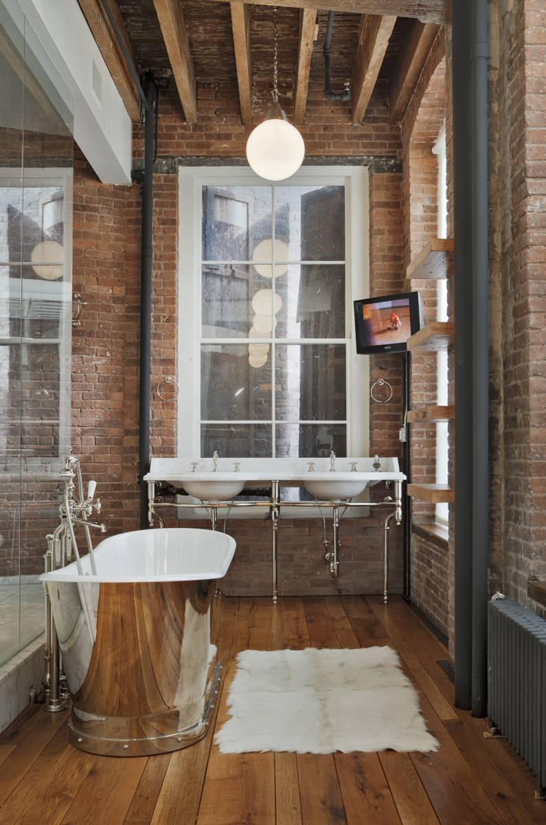 Small loft bathroom - with nickel bathtub and brick wall