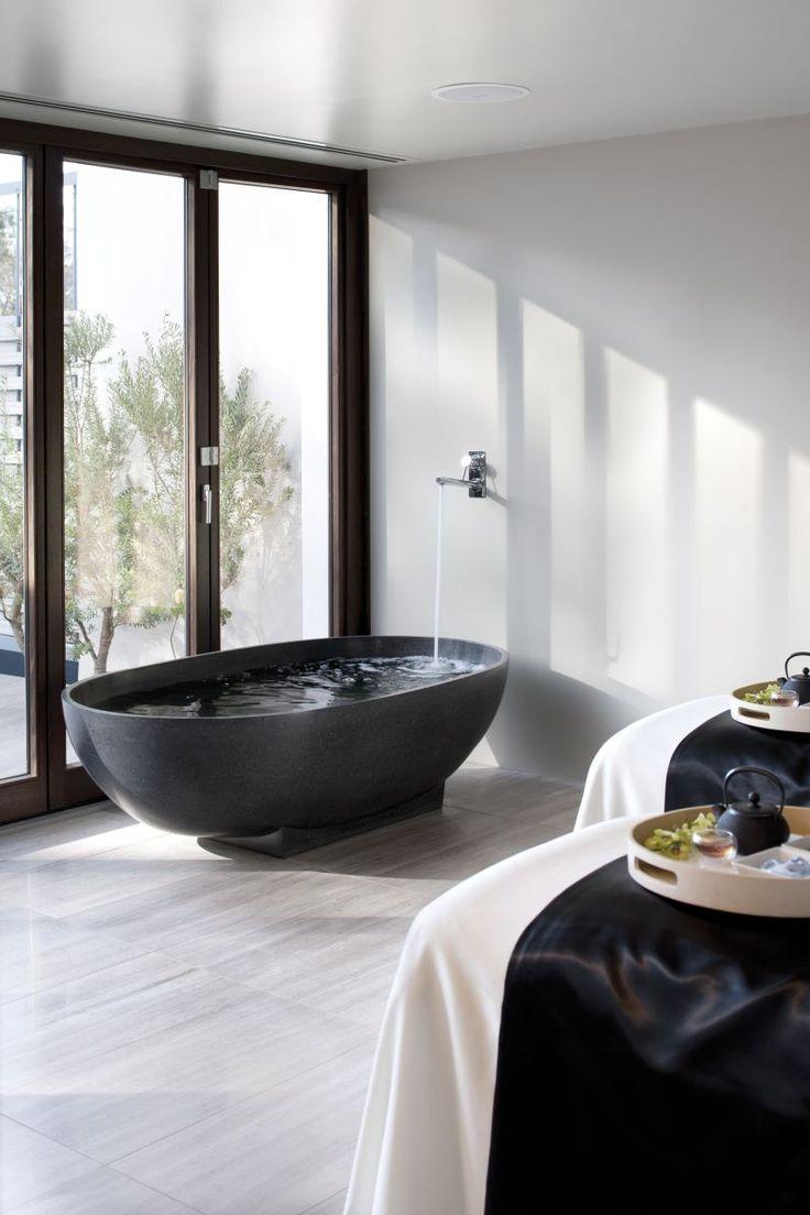 Modern black luxurious bathtub - in a minimalist bathroom